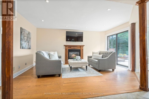 Living room with a fireplace, two sofas, an ottoman, and a mounted television. - 4 Pine Ridge Road, Erin
