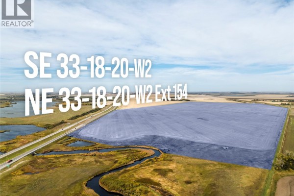 Aerial view of cultivated land with blue overlay, highlighting land parcels next to a highway and water. - 4 Quarters Development Land Near Regina, Sherwood Rm No  159