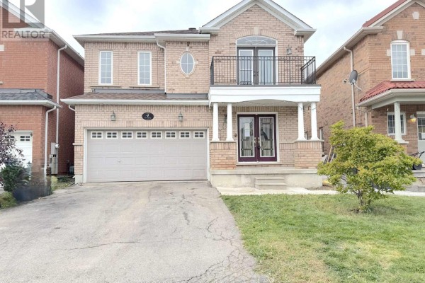 Front view of the house showing a beige garage door and double front doors. - 4 Savita Road, Brampton