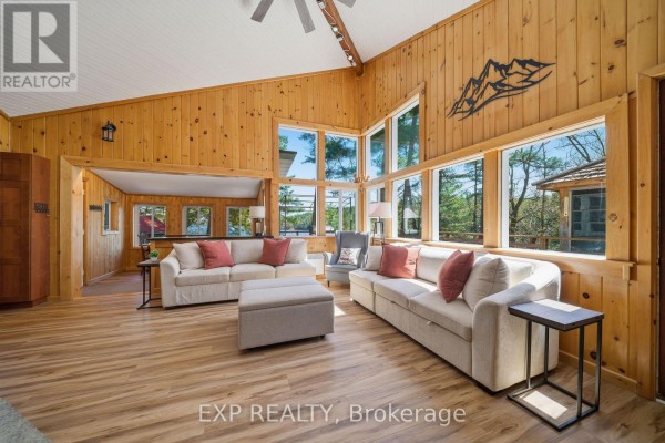 Spacious living area with ample windows, wooden paneling, and comfortable seating overlooking the outdoors. - 4 Stackwall Lane, Greater Madawaska