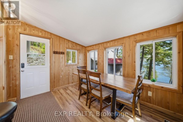 Wooden dining room with lake view, table, chairs, and door - 4 Stackwall Lane Greater Madawaska