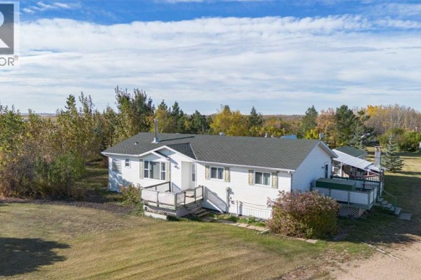 Exterior of a white mobile home with a green roof, decks, and surrounded by trees. - 4 Trestle Close, Rural Stettler No  6, County Of