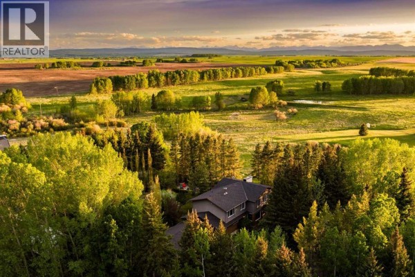 A large hoop greenhouse with white translucent sheeting sits in a field of tall grass. - 4 West Meadows Estates Road, Rural Rocky View County