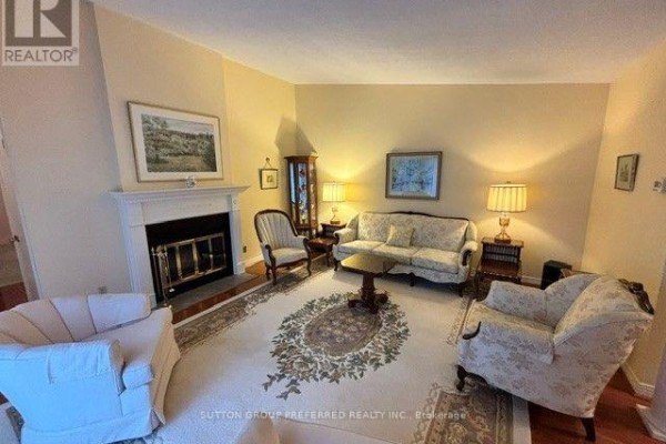 Living room with a fireplace, two sofas, two armchairs, and a side table with lamps. - 40 - 60 Fiddlers Green Road, London North