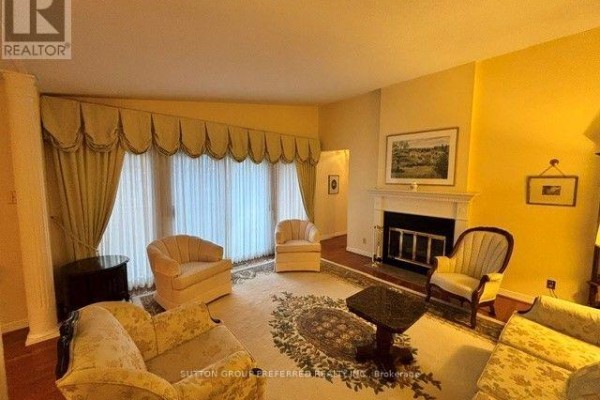 Living room with sofas, armchairs, a fireplace, and large windows with decorative curtains. - 40 - 60 Fiddlers Green Road, London North