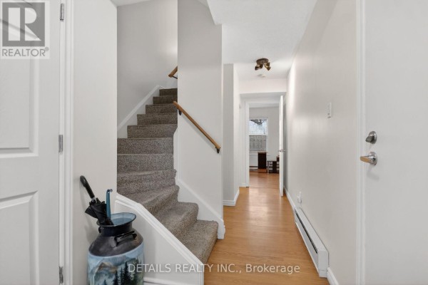 Interior hallway with staircase, light wood floor, and doors leading to rooms. - 40 Appleby Private, Ottawa