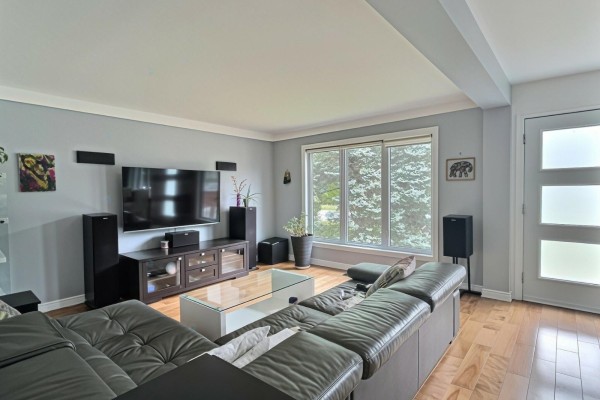 Living room with a large sectional sofa, entertainment unit, and hardwood floors. - 40 Ch. Cochrane, Gatineau