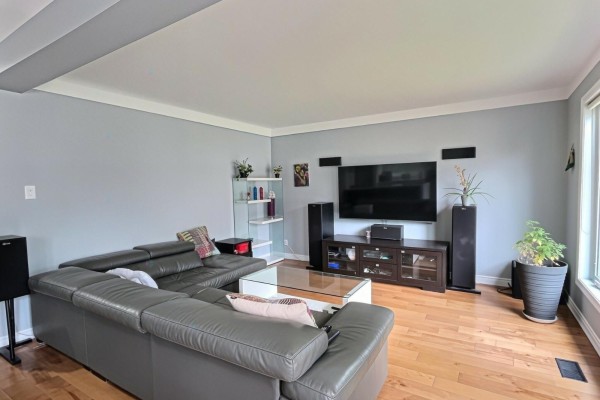 Living room with a sectional sofa, hardwood floors, and a view through the window. - 40 Ch. Cochrane, Gatineau
