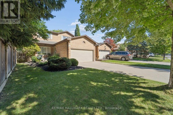 Front exterior of a brick house with a driveway, lawn, and trees. - 40 Colonel Butler Drive, Markham