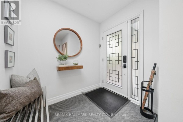 Interior foyer with a bench, circular mirror, umbrella stand, and frosted glass door. - 40 Colonel Butler Drive, Markham
