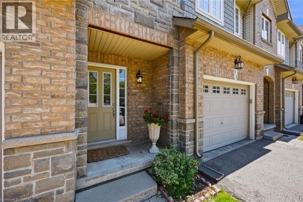 Close-up view of the front entrance of a townhouse with brick and stone details. - 40 Dartmouth Gate Unit# 10, Stoney Creek