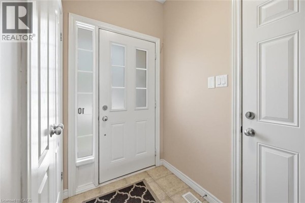 Interior view of the townhouse entryway with a white door and tile flooring. - 40 Dartmouth Gate Unit# 10, Stoney Creek