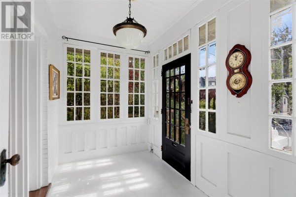 Sunroom interior with white walls, a black glass-paned door, and large windows. - 40 Euclid Rd, Sault Ste  Marie