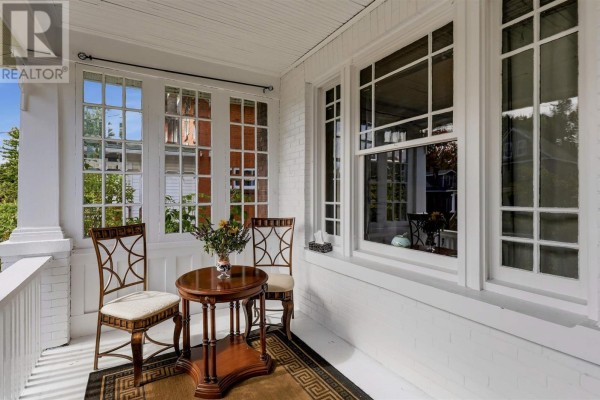 Porch detail with white railings, chairs, a small table, and large windows. - 40 Euclid Rd, Sault Ste  Marie