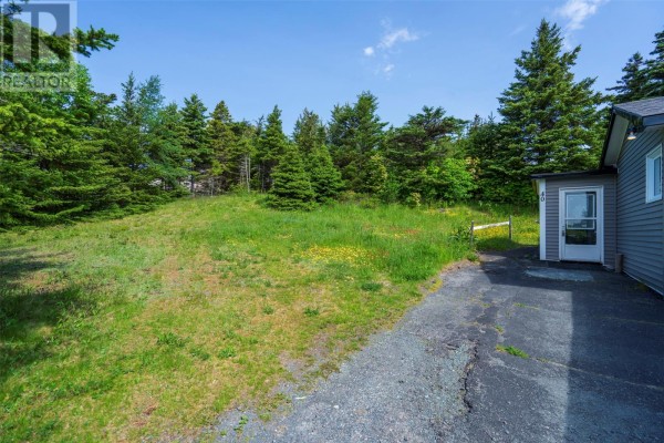 Side and front view of a grey bungalow with a driveway and trees. - 40 Godsells Road, Spaniards Bay