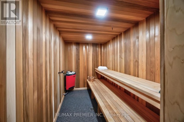 Sauna room with wood paneling, heater, and benches - 40 Golf Avenue Vaughan