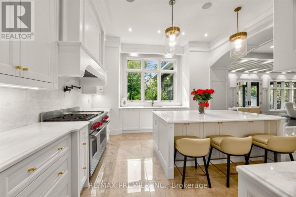 Modern white kitchen with island, gas range, marble counters & pendant lights - 40 Golf Avenue Vaughan