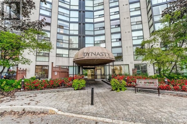 Building entrance with a wide canopy labeled 'Dynasty' and landscaping with red flowers and green bushes. - 40 Harding Boulevard Unit# 603, York