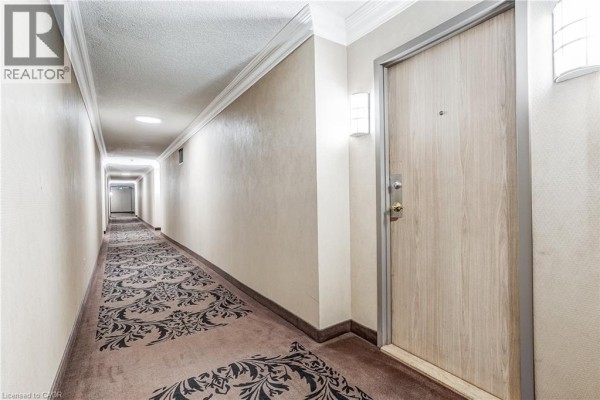Long, carpeted hallway with a patterned runner and recessed lighting leading towards elevator doors at the far end. - 40 Harding Boulevard Unit# 603, York