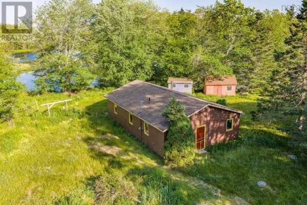 Exterior view of a brown wooden cabin with yellow trim and a red door. - 40 Mcgillis Island, Middle Ohio