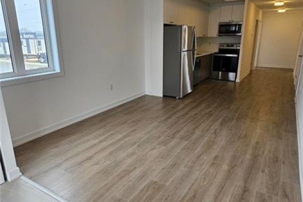 Living area and kitchen with light wood-look flooring, stainless steel refrigerator, and stainless steel oven. - 40 Palace Street Unit# J2, Kitchener