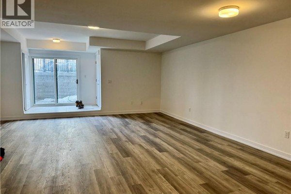 Unfinished basement area with a sliding glass door walkout and light wood-look flooring. - 40 Palace Street Unit# L24, Kitchener