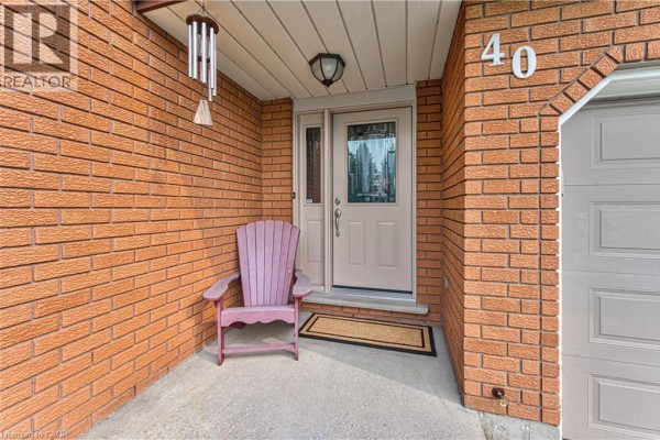Entrance porch with a pink Adirondack chair, brick wall, and glass-paned door. - 40 Peter Street, Scotland