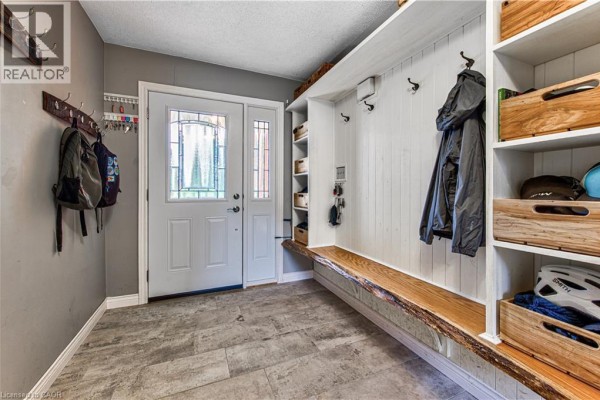 Interior entryway with tiled floor, white door, and built-in storage bench. - 40 Peter Street, Scotland