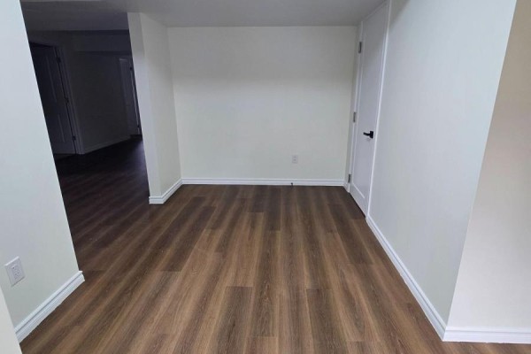Interior hallway with white walls, wood-look vinyl flooring, and white trim. - 40 Rosanne Drive, Wasaga Beach
