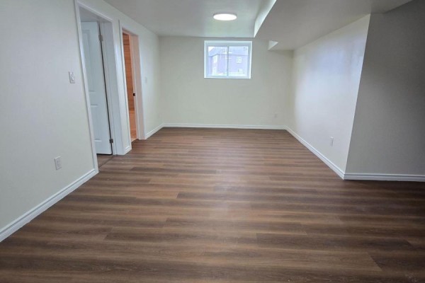 Empty room with cream walls, wood-look vinyl flooring, and a small window. - 40 Rosanne Drive, Wasaga Beach