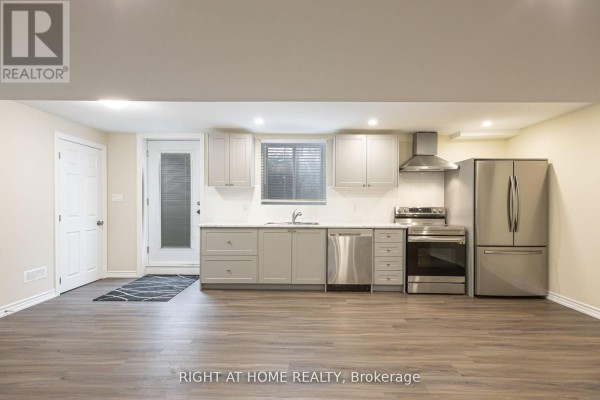Basement kitchen with light grey cabinets, white countertops, stainless steel appliances, and laminate flooring. - Basement - 40 Sabbe Crescent, Ajax