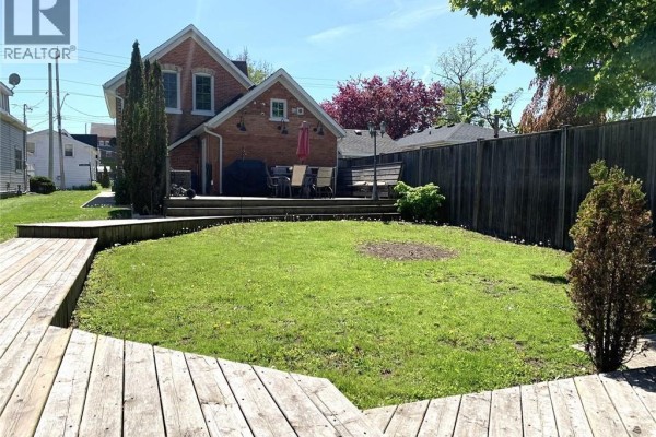 Grey shed with sliding doors and windows on a wooden deck, with a glass table and chairs. - 40 St Andrew Street, Port Dover