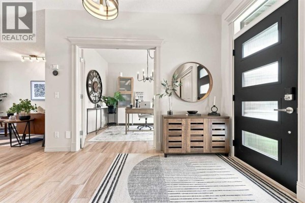 View from the entryway into a home office with a desk and shelving. - 40 Tuscany Glen Park Nw, Calgary