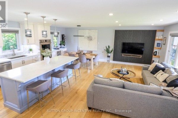 Open concept kitchen and dining area with blue island and grey chairs. - 40 Varden Avenue, Barrie