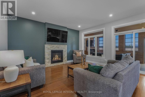 Wood-paneled sunroom with comfortable seating, electric fireplace, and ceiling fan. - 400 Colmar Street, Russell