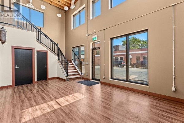 Commercial interior space with brown and tan walls, patterned carpet, and exposed ceiling joists. - 400 Erie Street East Unit# 1 & 2, Windsor