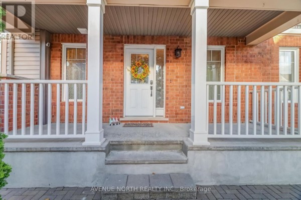 Covered front porch with white railings, brick exterior, and a white front door with glass panels. - 400 Meadowhawk Crescent, Ottawa