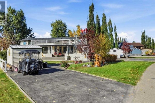Driveway and yard of the mobile home, with a shed and golf cart. - 4001, 35468 Range Road 30, Rural Red Deer County