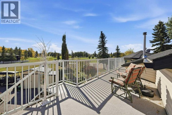 View from the upper deck overlooking a green landscape with trees and buildings. - 4001, 35468 Range Road 30, Rural Red Deer County