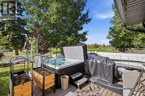 Hot tub and grill on a wooden deck with planter boxes nearby. - 4001, 35468 Range Road 30, Rural Red Deer County