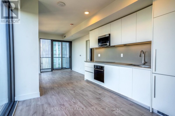 Modern kitchen with white cabinets, stainless steel appliances, and light wood floors. - 4002 - 8 Cumberland Street, Toronto