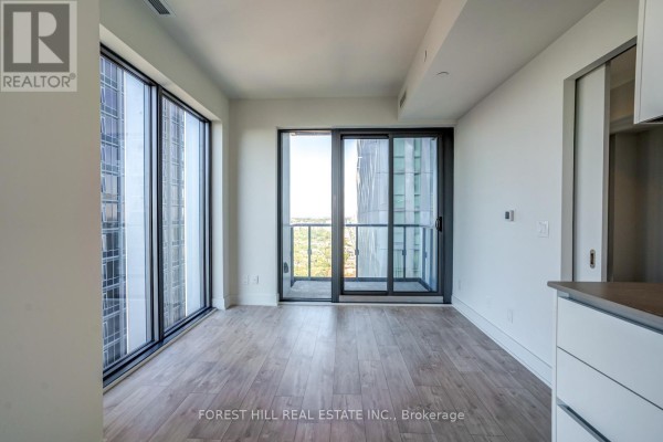 Living area with large windows, balcony door, and light wood floors. - 4002 - 8 Cumberland Street, Toronto