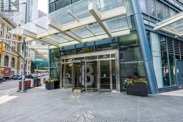 The glass and metal entrance to an urban apartment building. - 4004 - 8 The Esplanade, Toronto