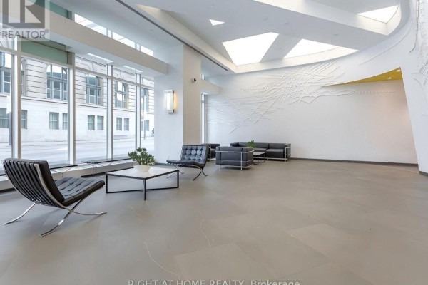 A contemporary lobby with large windows, white walls, and modern seating. - 4004 - 8 The Esplanade, Toronto