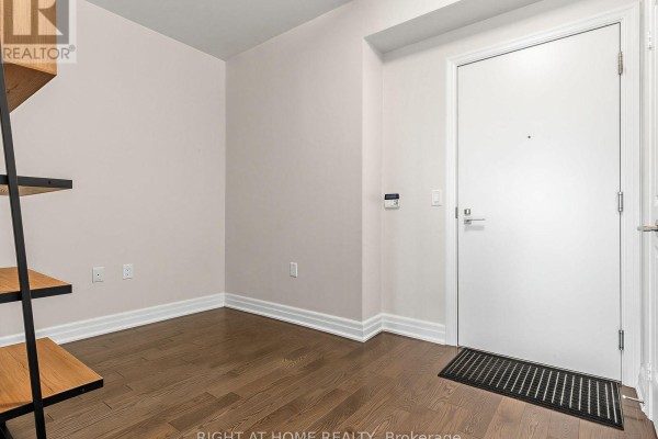 A narrow hallway with hardwood floors, a door, and a minimalist shelf unit. - 4004 - 8 The Esplanade, Toronto