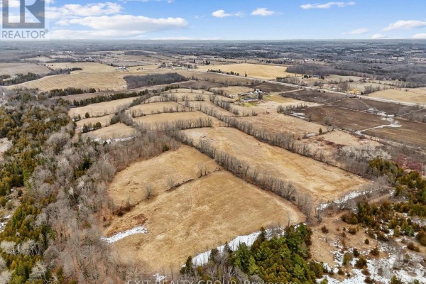 Expansive aerial view of rural farmland with fields, trees, and scattered buildings. - 4006 Stirling Marmora Road, Stirling Rawdon