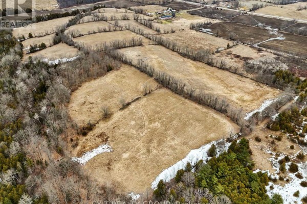 Overhead view of a large, open field bordered by trees and distant rural landscape. - 4006 Stirling Marmora Road, Stirling Rawdon