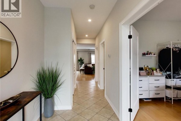 Interior hallway with beige tiled floors, light grey walls, and a large mirror. - 4007 Bush Crescent, Beamsville