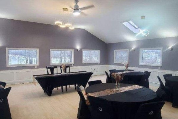 Interior event space with round tables covered in black cloths and a long rectangular table. - 4008 Moneymore Road, Tweed)