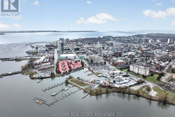 Aerial view of a city skyline with a large body of water and a marina in the foreground. - 401 - 350 Wellington Street, Kingston
